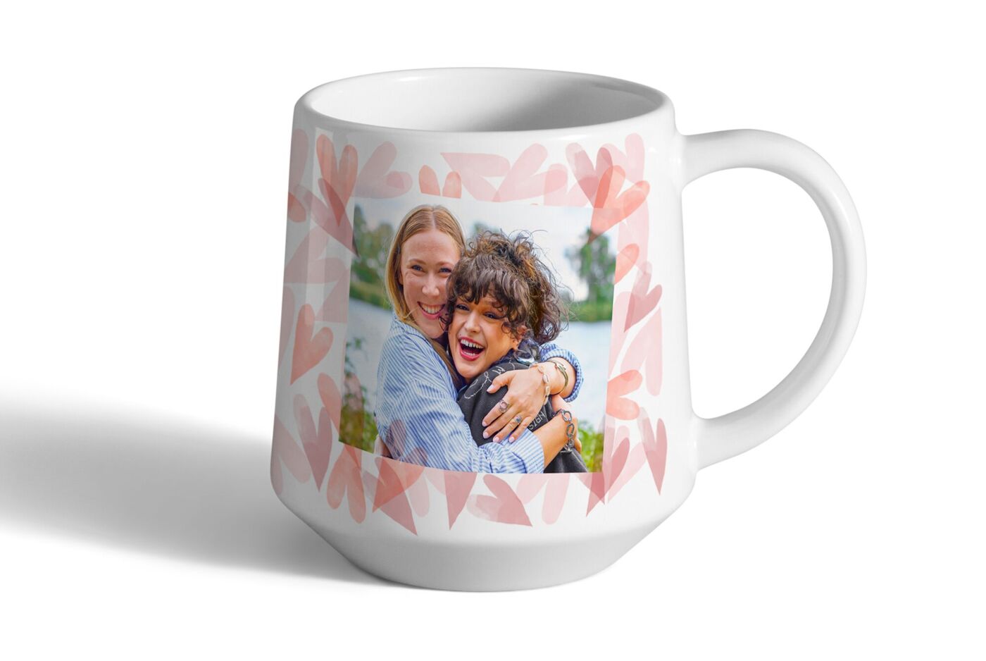 Persönlicher Foto-Kaffeebecher in moderner Form mit fröhlichem Foto von zwei Personen, die sich umarmen und lachen.