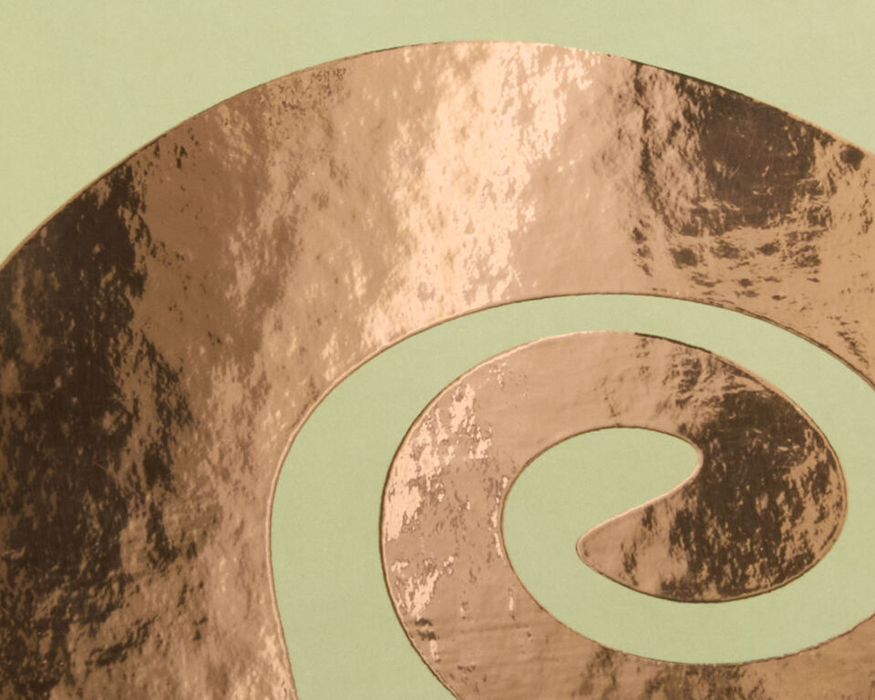 Zarte Spiralmuster in Roségold-Veredelung auf grünem Hintergrund.