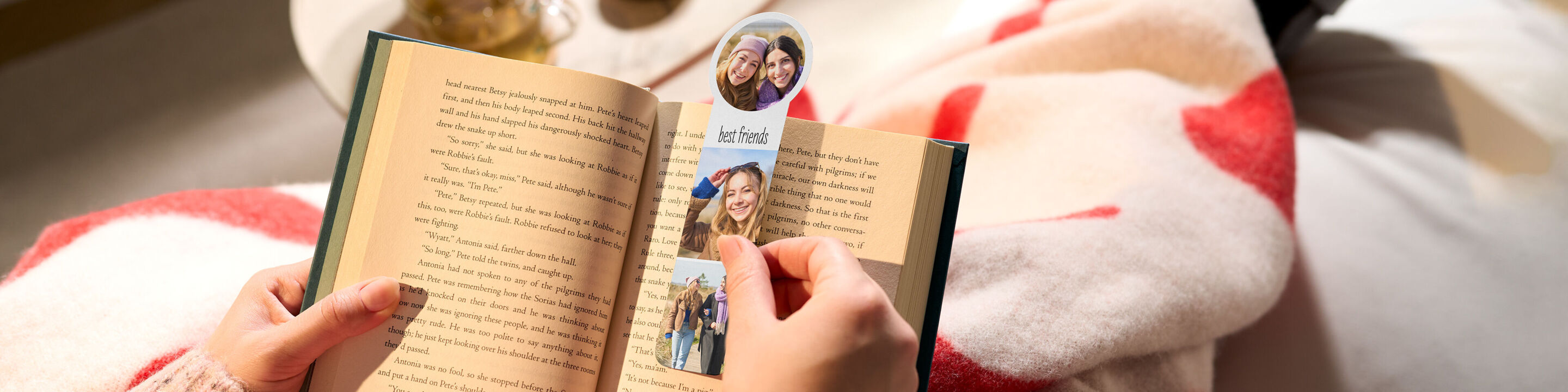 Person hält ein Buch und ein personalisiertes Foto-Lesezeichen mit Bildern von Freundinnen und dem Schriftzug "best friends".