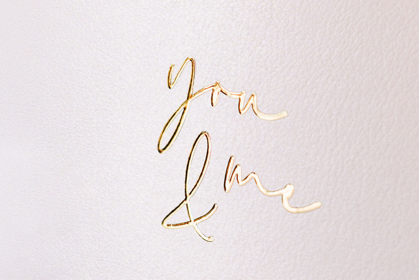 Weißes CEWE FOTOBUCH mit Ledereinband und Schriftzug "you & me" mit Goldveredelung