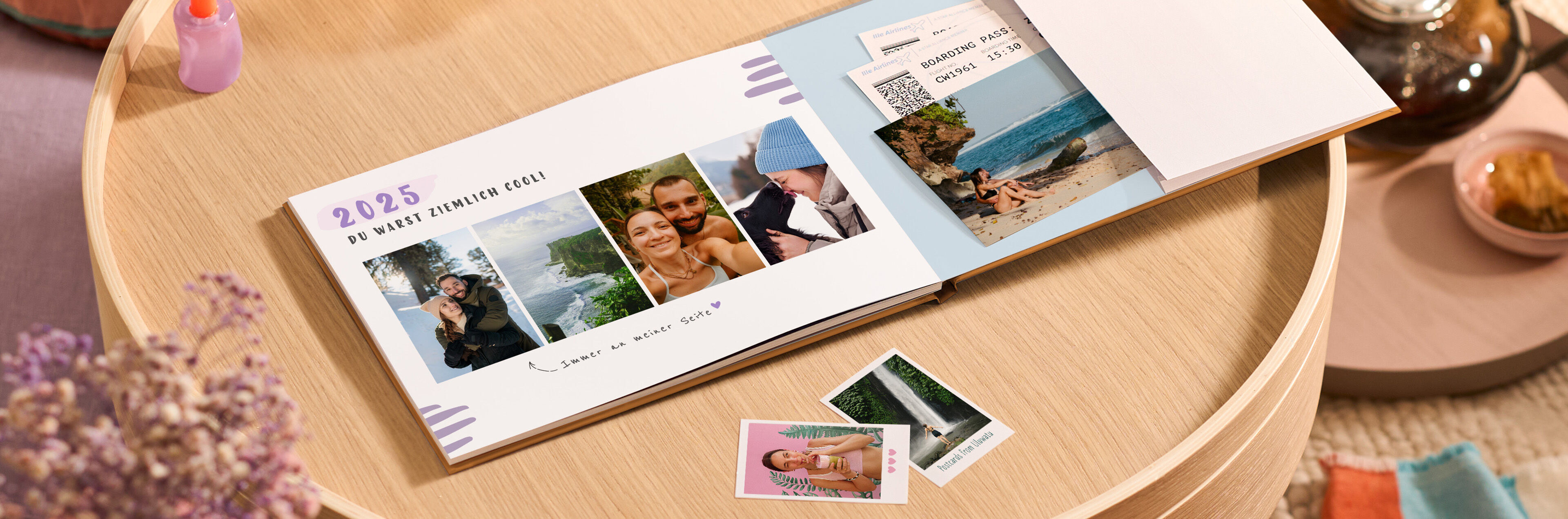 Ein geöffnetes CEWE FOTOBUCH mit Urlaubsfotos, umgeben von Erinnerungsfotos.
