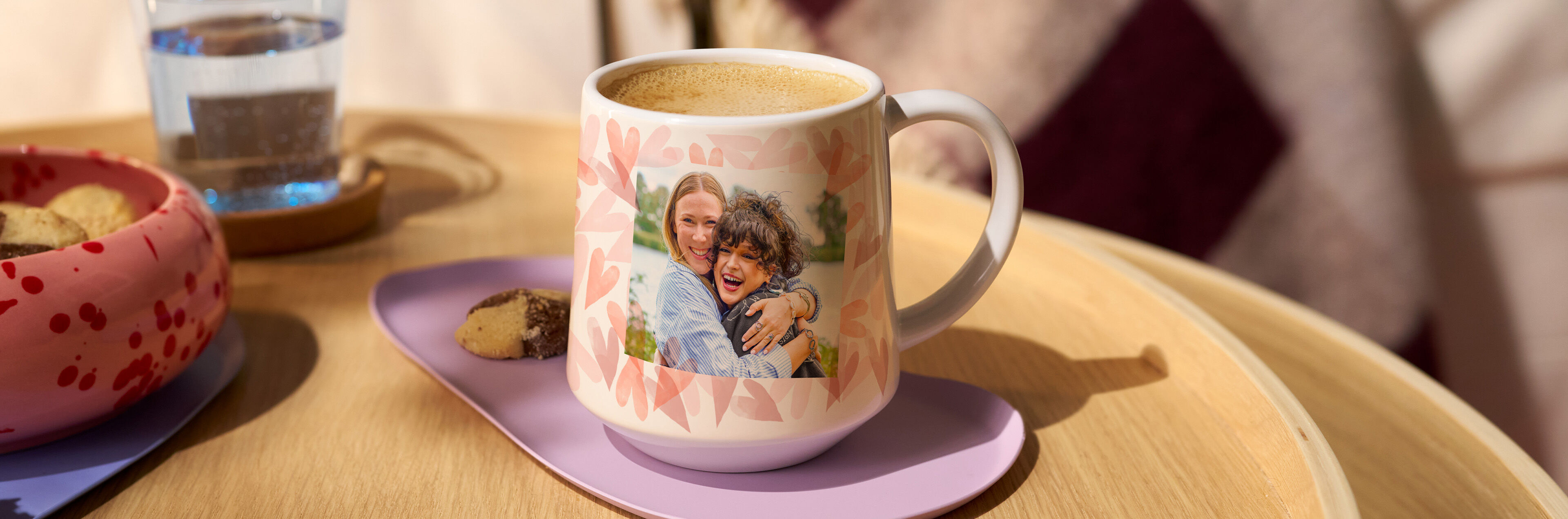 Eine personalisierte Tasse mit einem Foto von zwei lächelnden Personen, umgeben von einem herzlichen Muster.