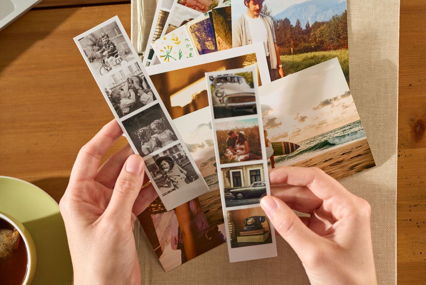 Zwei Hände halten zwei Fotostreifen mit jeweils vier kleinen Bildern, darunter Erinnerungen aus dem Alltag