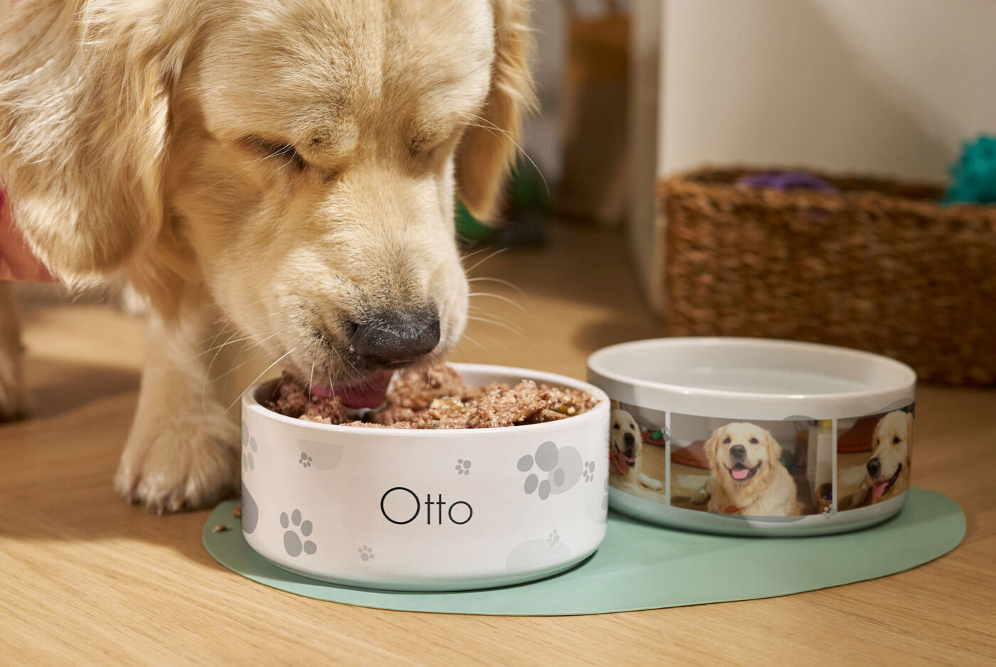 Ein Golden Retriever frisst aus einem personalisierten Futternapf mit seinem Namen, daneben ein personalisierter Wassernapf mit Fotos von ih