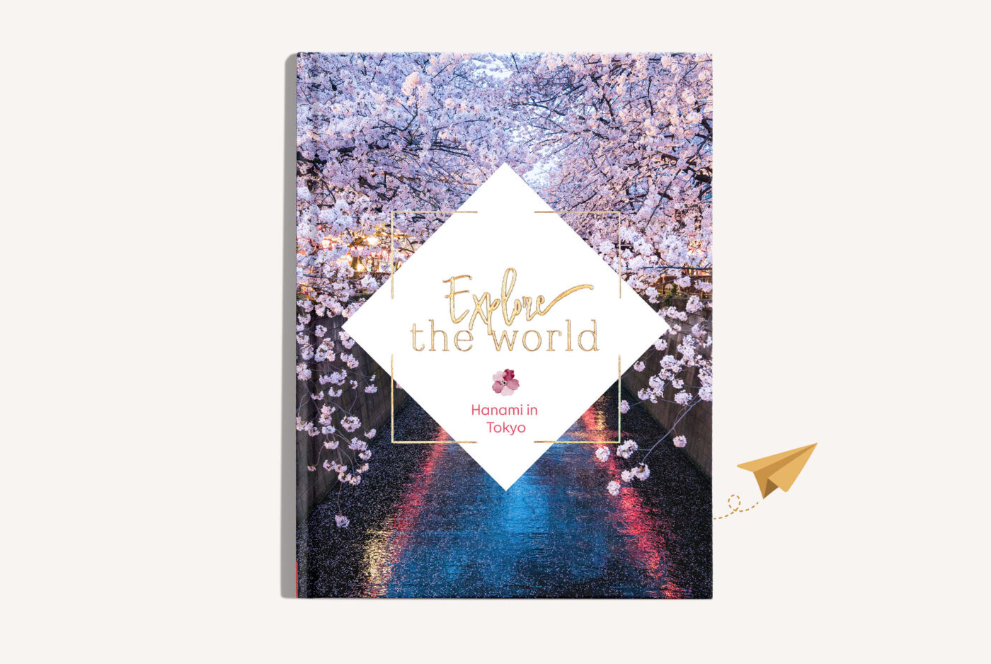 CEWE FOTOBUCH mit einem Bild von blühenden Kirschblüten und dem Titel "Explore the world " mit Goldveredelung