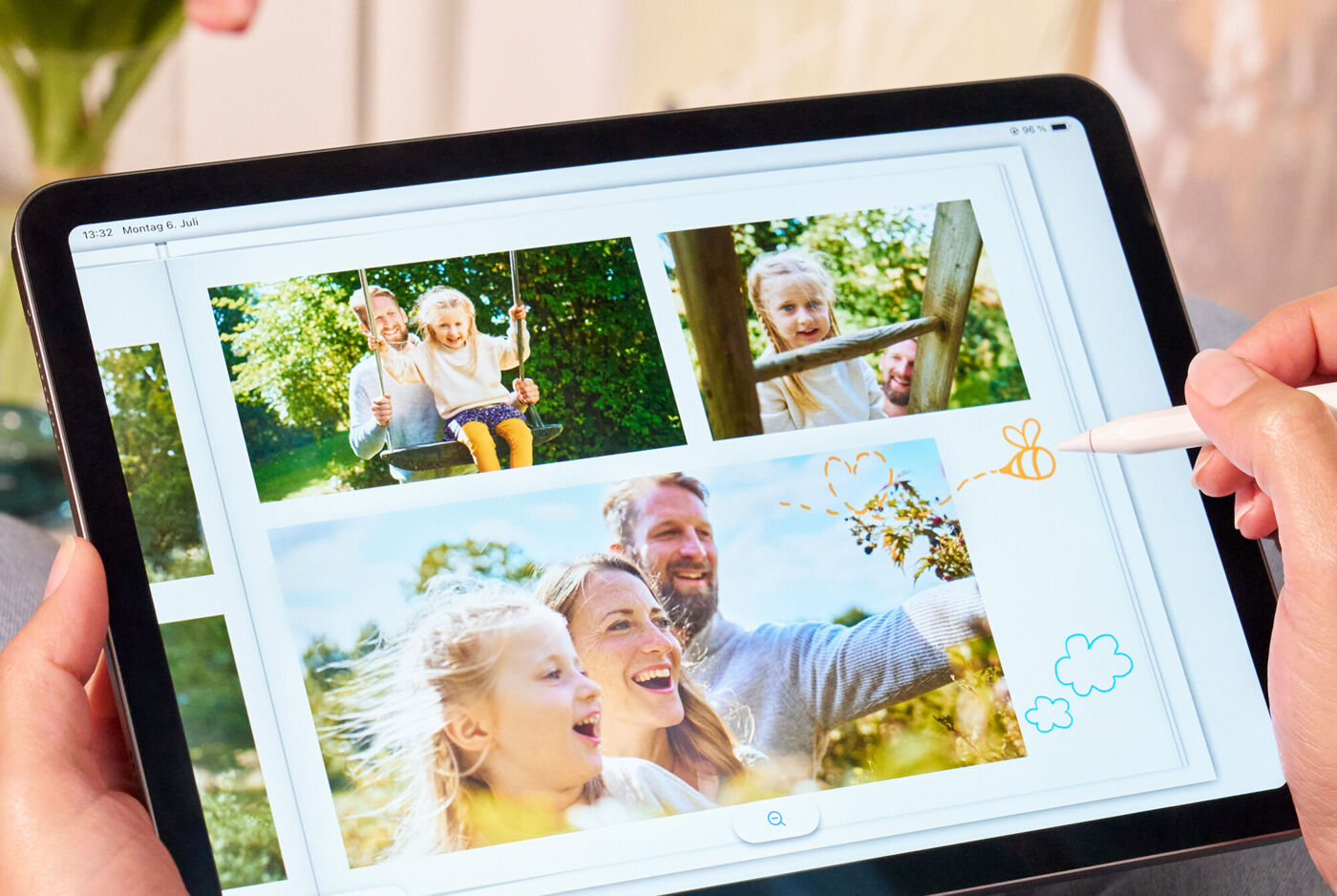 Tablet mit Familienfotos und bunten Zeichnungen, die mit einem Stfit bearbeitet werden.