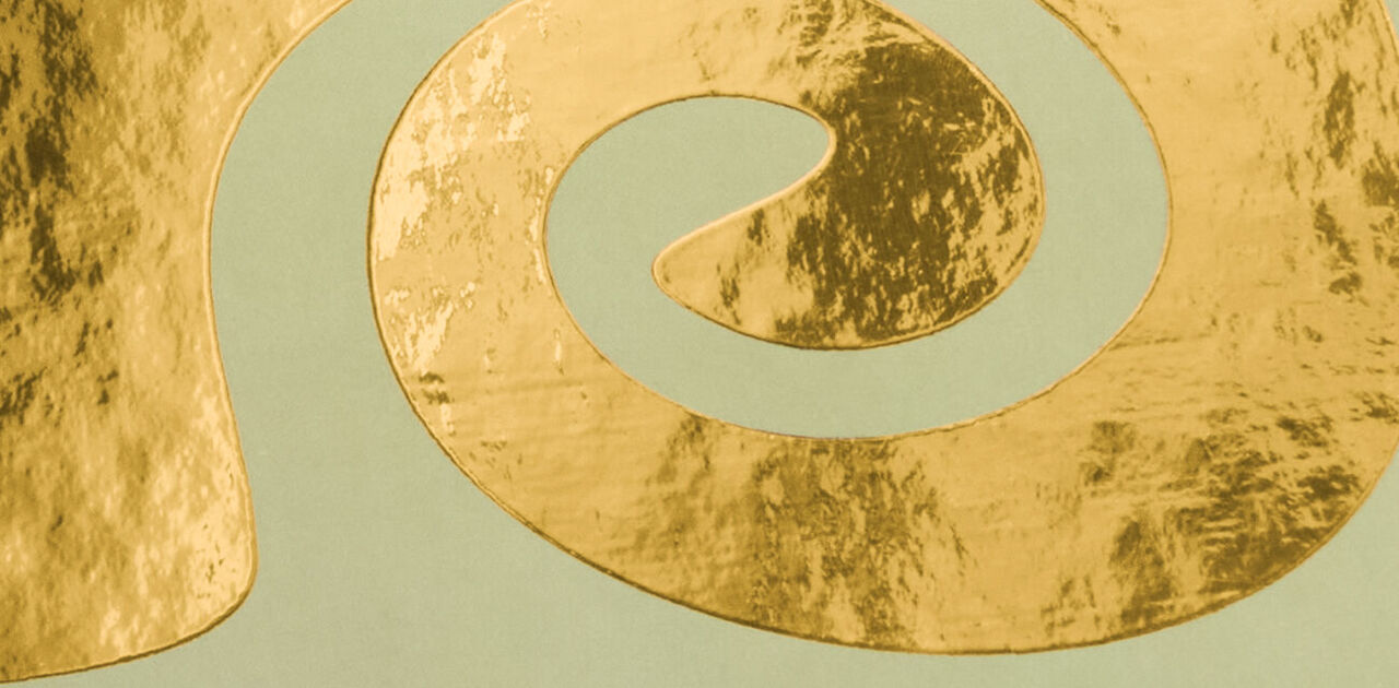 Spiralförmig geschwungene Goldveredelung auf mintgrünem Hintergrund.