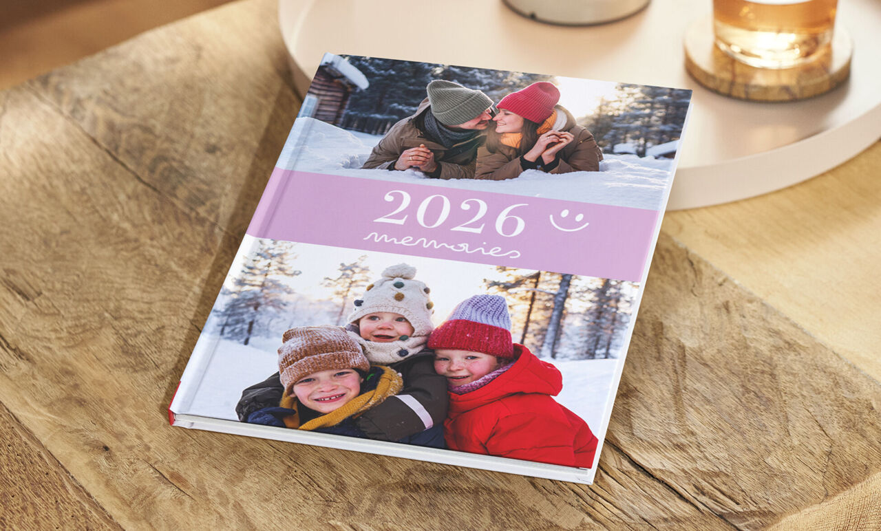 Ein Fotobuch mit winterlichen Familienfotos auf dem Cover, das sich mit eigenen Bildern erstellen lässt.