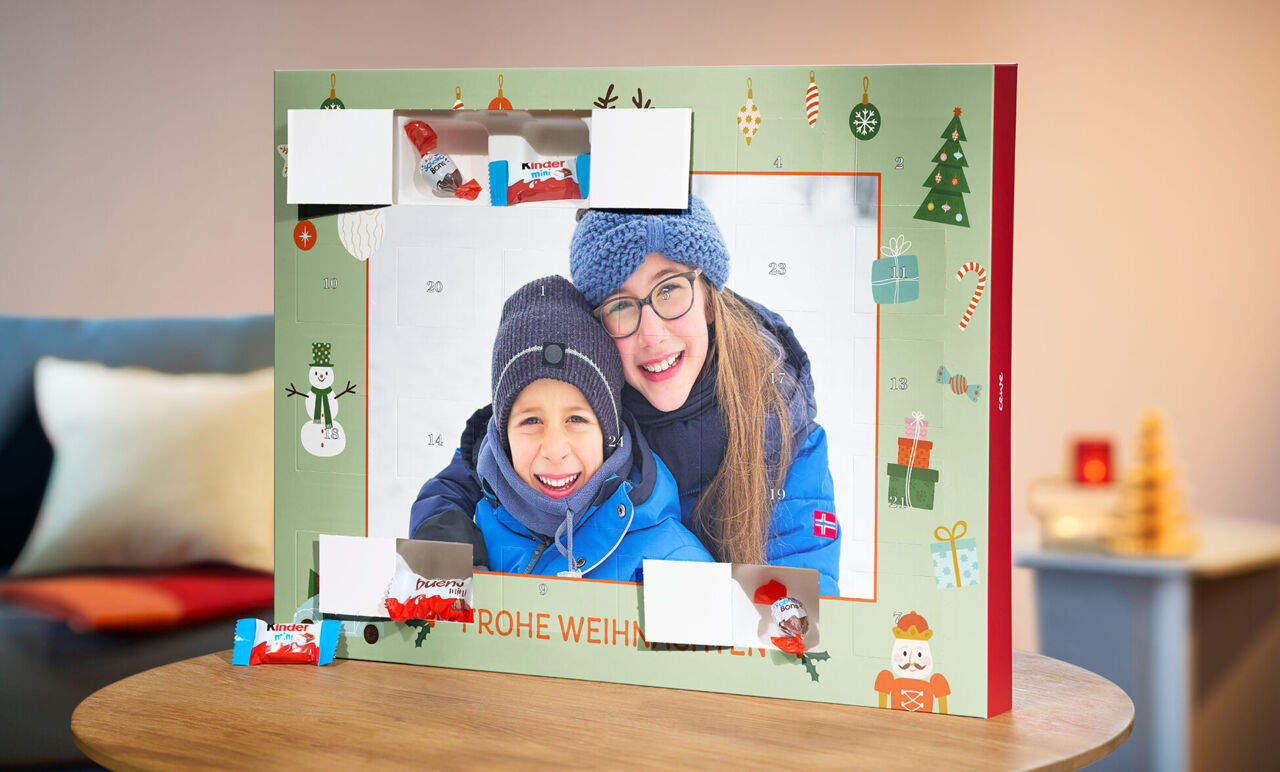 CEWE Adventskalender mit Winterfoto und drei geöffneten Türchen, in denen sich Produkte von kinder befinden.