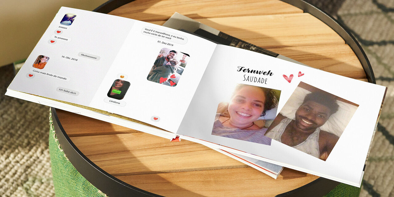 Ein CEWE FOTOBUCH liegt aufgeschlagen auf einem Holztisch. Auf der linken Seite sind Chatnachrichten gedruckt, auf der rechten Seite Selfies des Paares.