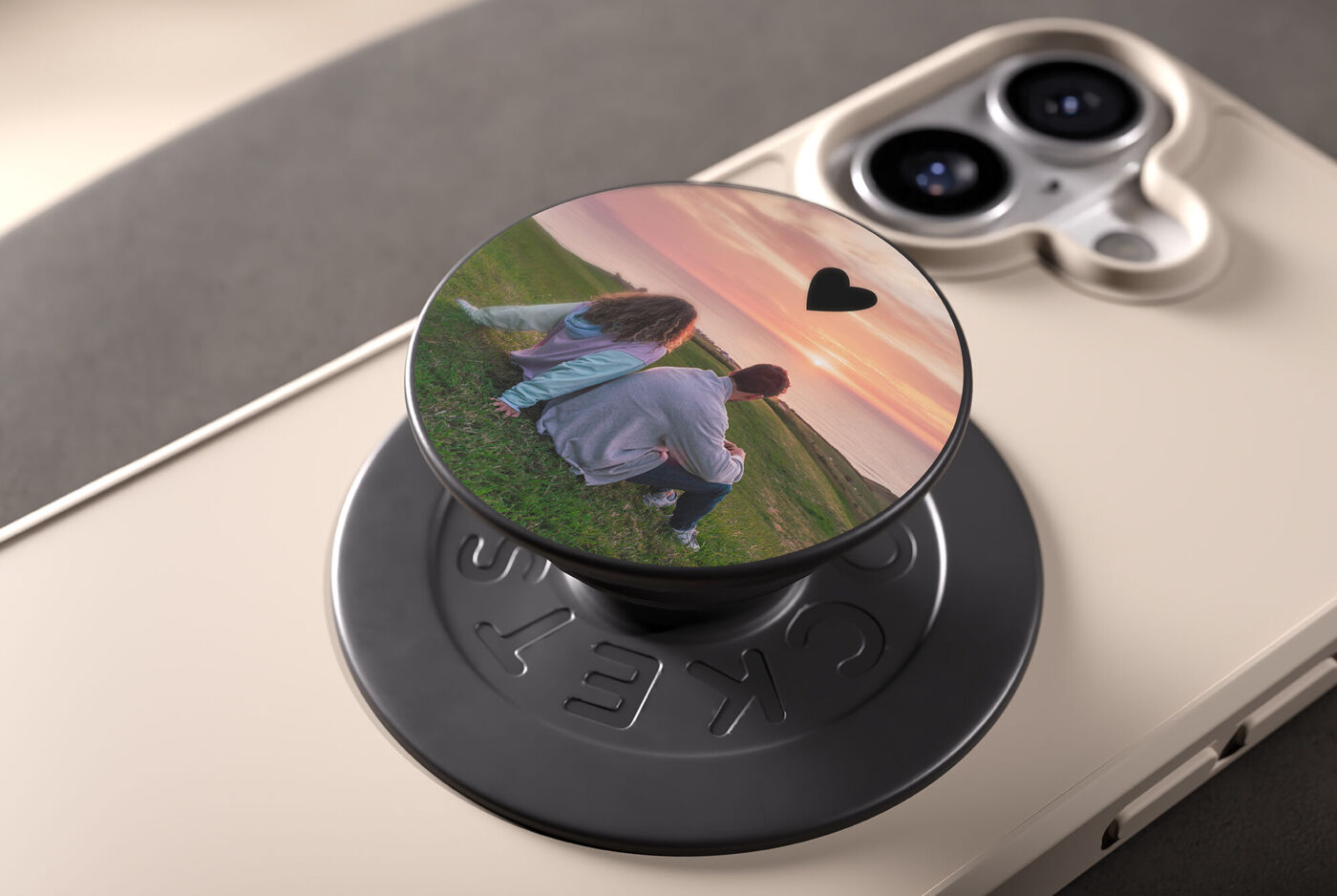 Personalisierter Pop Grip mit Paarfoto bei Sonnenuntergang auf einem Smartphone
