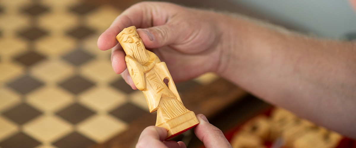 Jacob Fischer hält eine Schachfigur in der Hand.