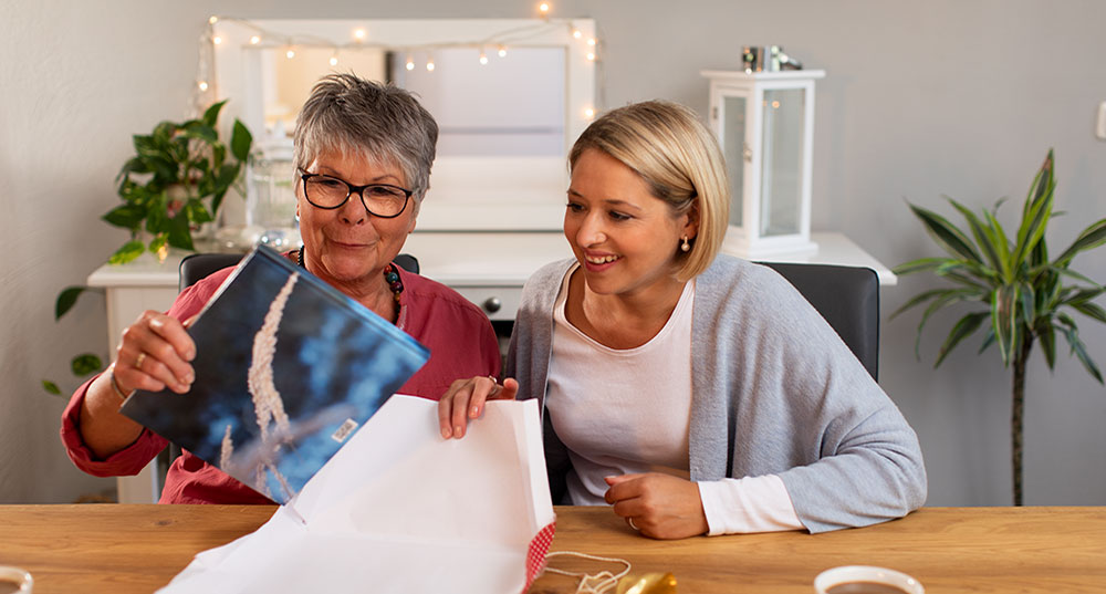 Uschi und Hannah Fischer packen gemeinsam ein CEWE&nbsp;FOTOBUCH aus.