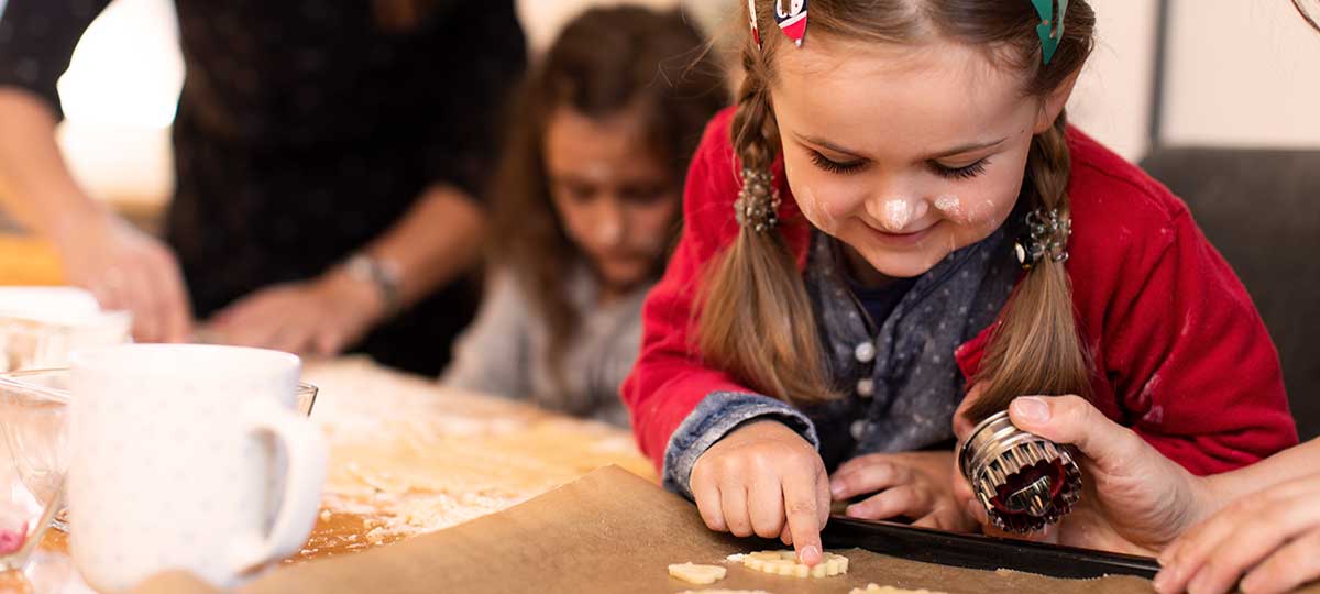 Tina Kneitz und Melanie Kofler backen mit ihren Töchtern Kekse.
