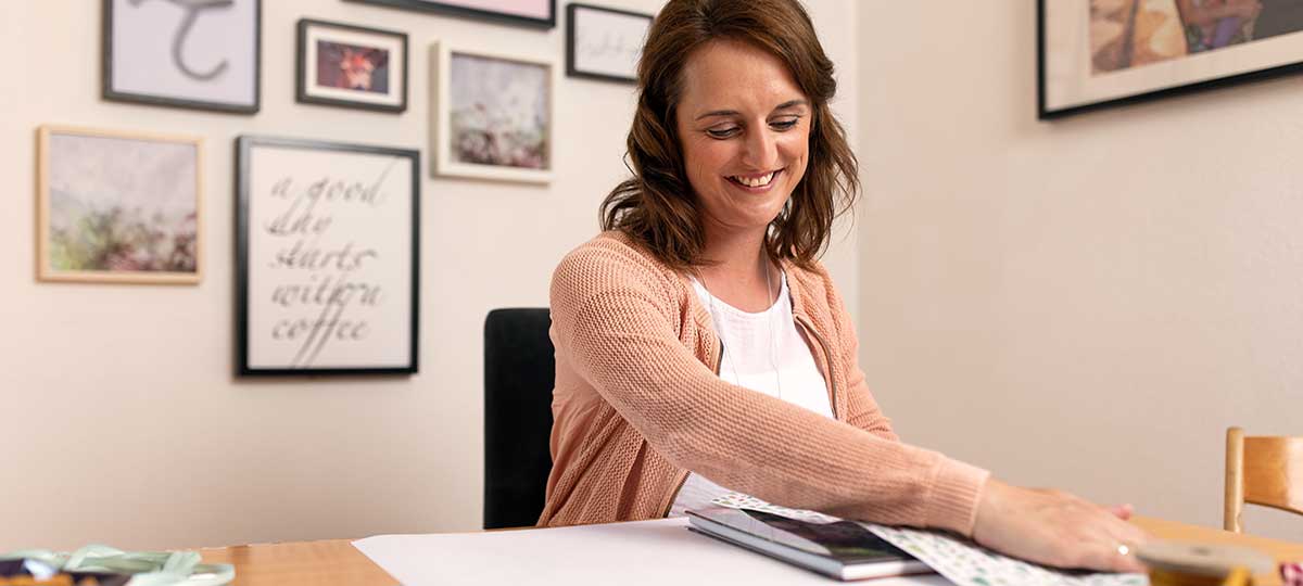 Tina Kneitz verpackt eines ihrer Fotobücher in Geschenkpapier.