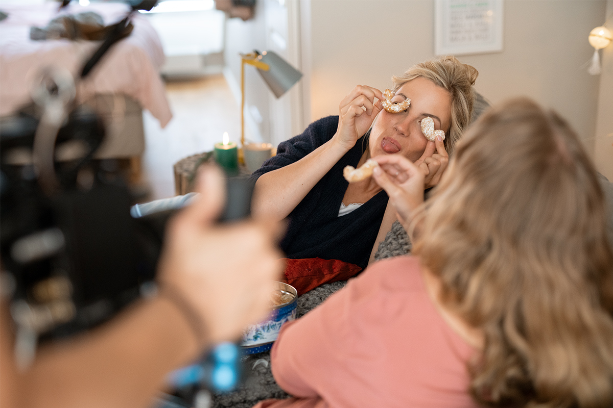Mareike hält sich die Kekse vor ihr Gesicht und streckt die Zunge raus.