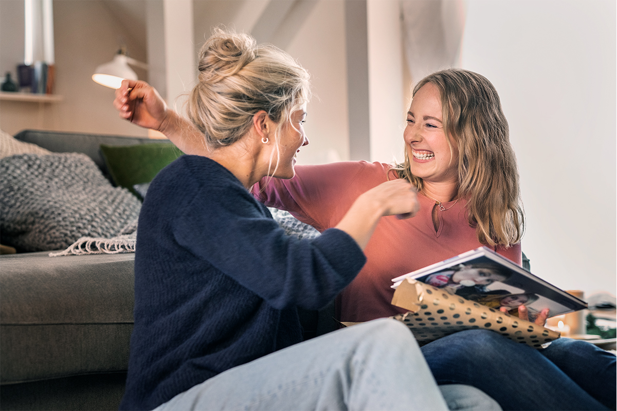 Carina und Mareike lachen und strecken die Arme zu einer Umarmung aus.