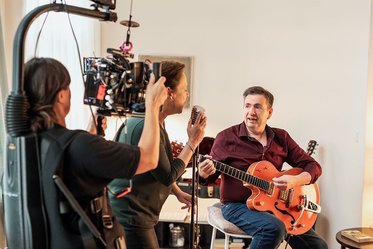 Britta singt am Mikrofon, während Carsten auf der Gitarre spielt.