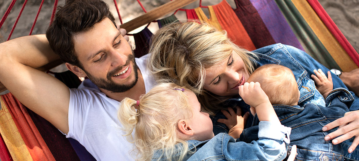 Familie Wernicke liegt im Garten zusammen in der Hängematte.