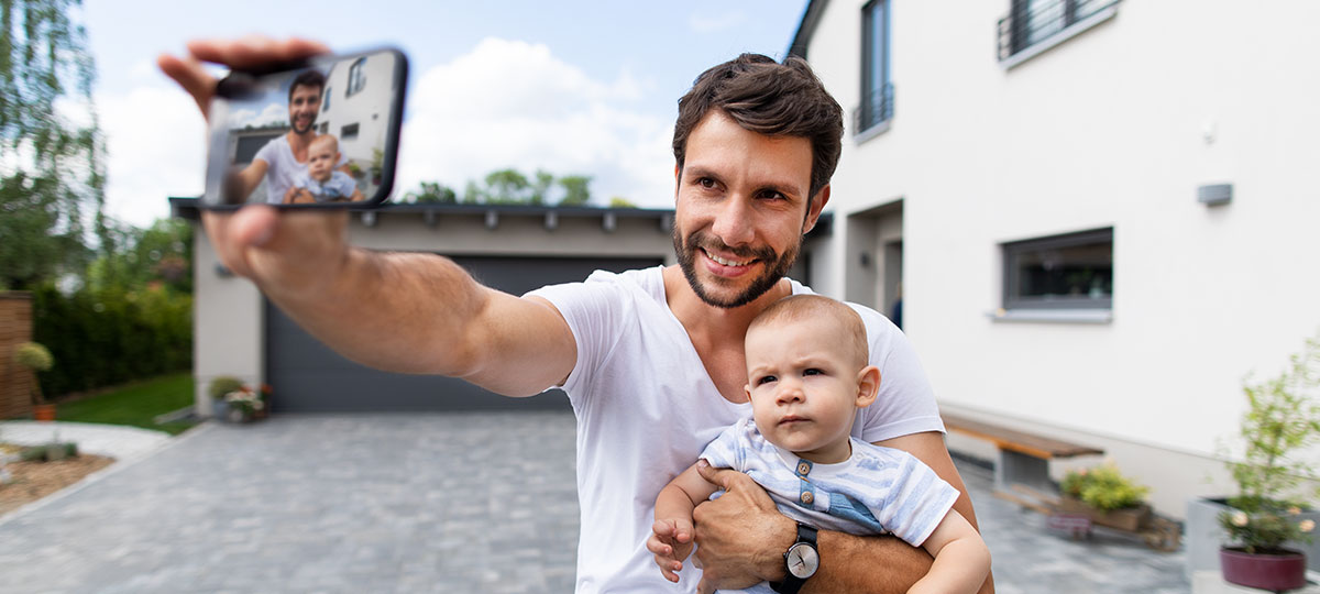 Martin Wernicke mit Sohn Matheo auf dem Arm - dabei macht er einen Selfie.