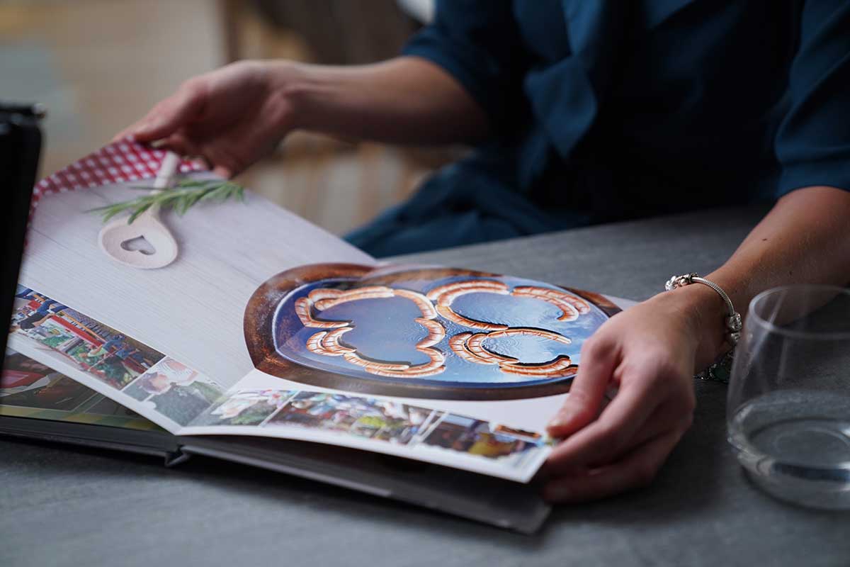 Marlén Wernicke hat eine Doppelseite aus dem Fotobuch zum 30. Geburtstag ihres Mannes aufgeschlagen.