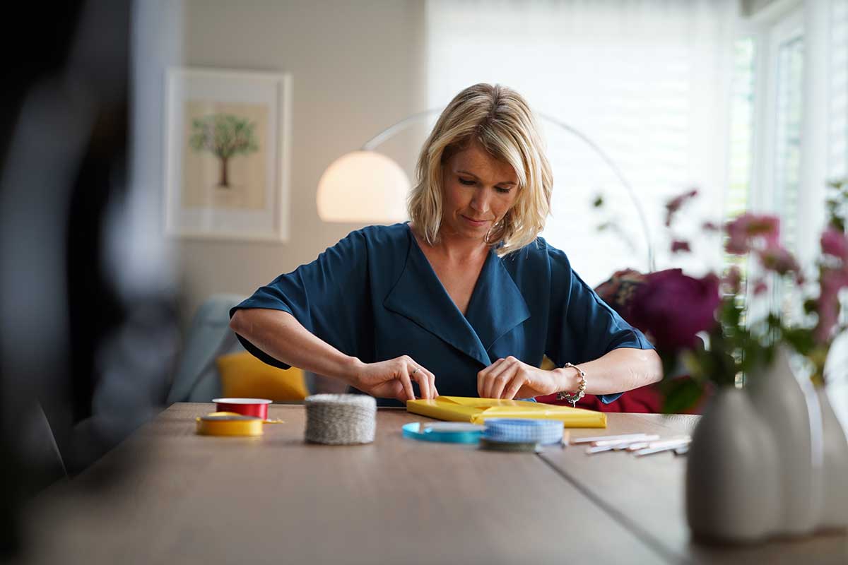 Marlén Wernicke packt ein CEWE FOTOBUCH ein.